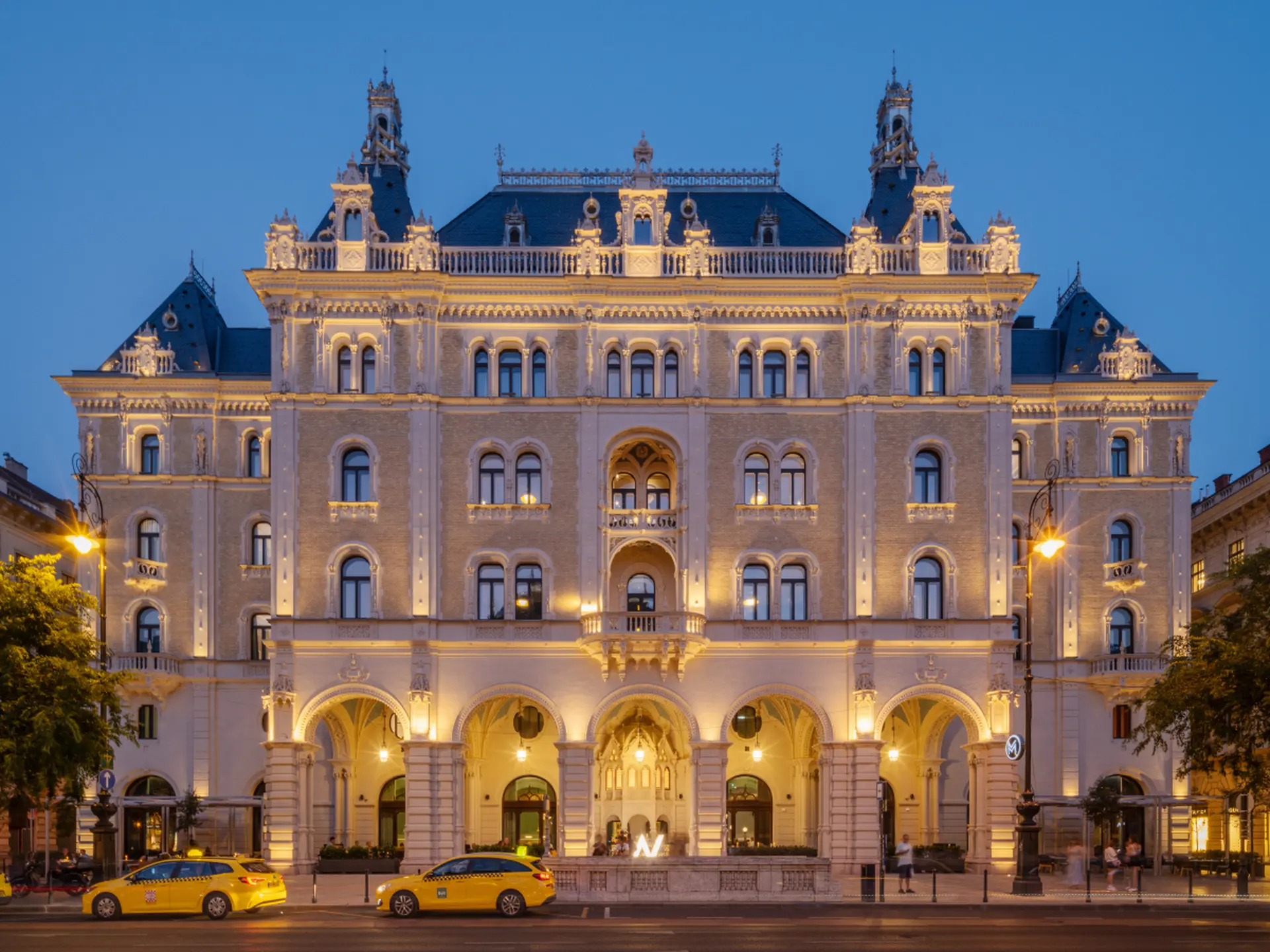 W Budapest szálloda éjszakai homlokzata, a Drechsler Palace historizáló épülete kivilágítva